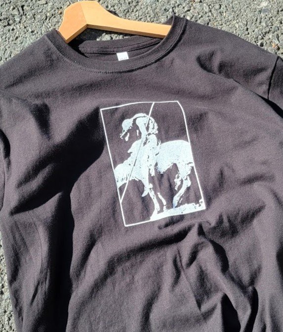 Crisis Hotline merch: dark gray t-shirt with a white horse-and-rider graphic on a hanger