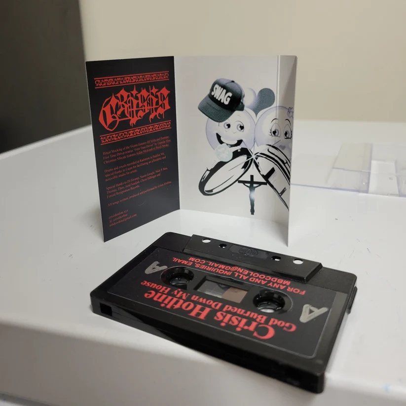 God Burned Down My House cassette by Crisis Hotline with its open insert and black tape
